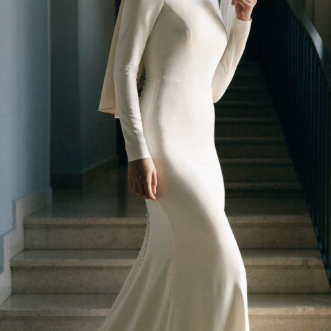 Bride in ivory stretch crepe mermaid gown with high neck, long sleeves and hijab on stairs